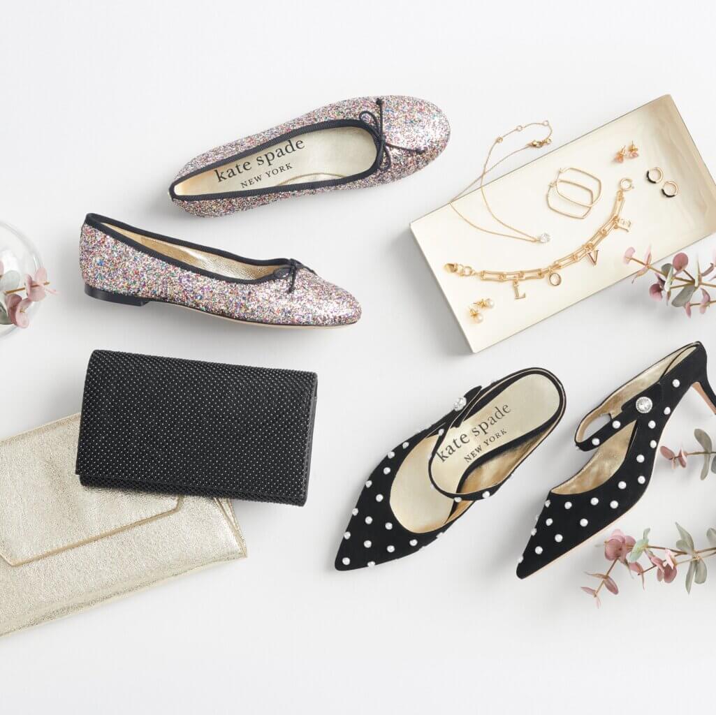 Stitch Fix women’s formal wedding attire outfit accessories with flats, pearl mule slides and clutches next to gold jewelry on a tray.