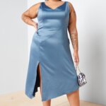 Stitch Fix model wearing plus size women’s semi-formal wedding attire outfit with blue satin dress, printed handbag and white heels.