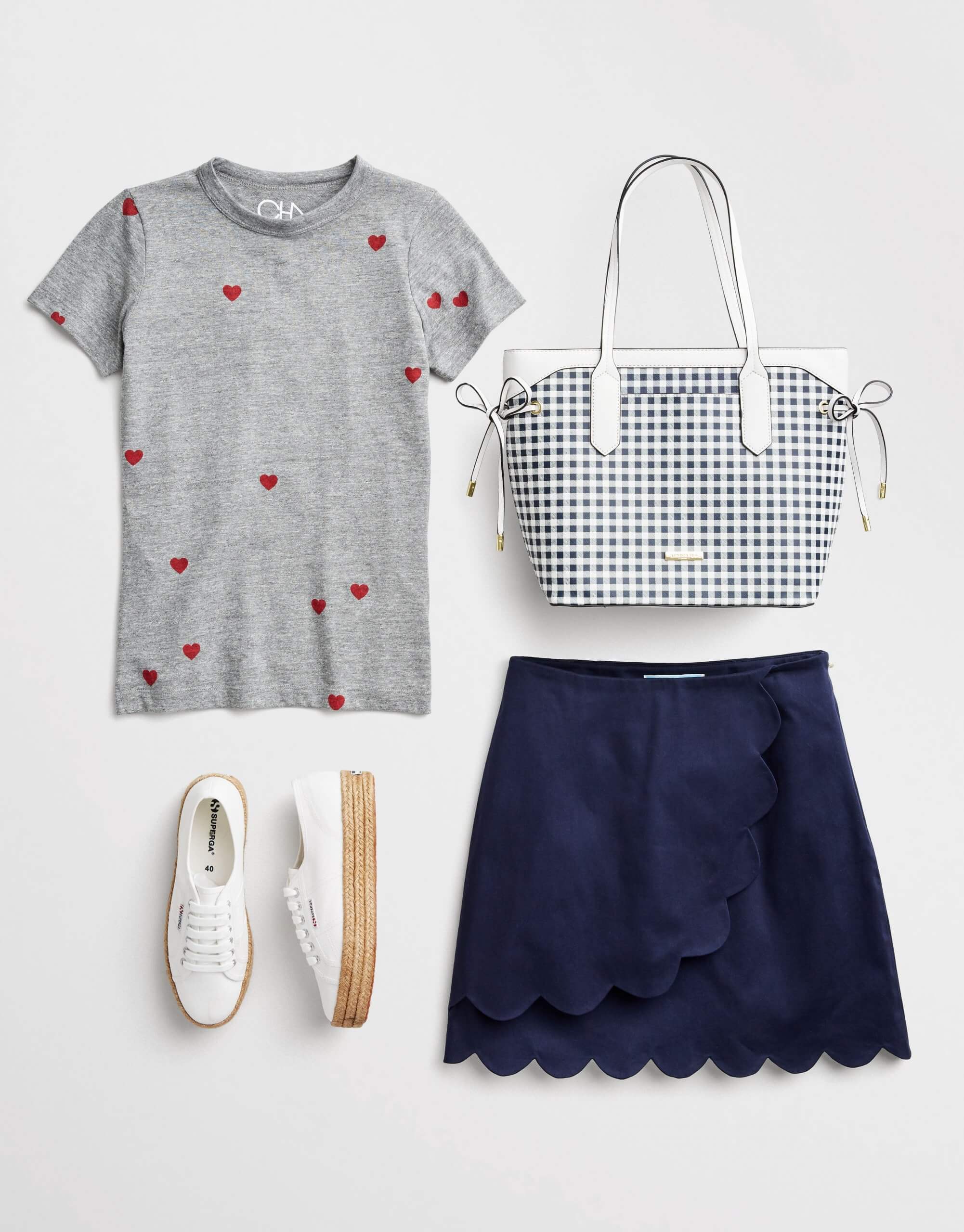 Stitch Fix women's 4th of July outfit laydown featuring a navy skirt, grey tee with heart print, white sneakers and striped purse.