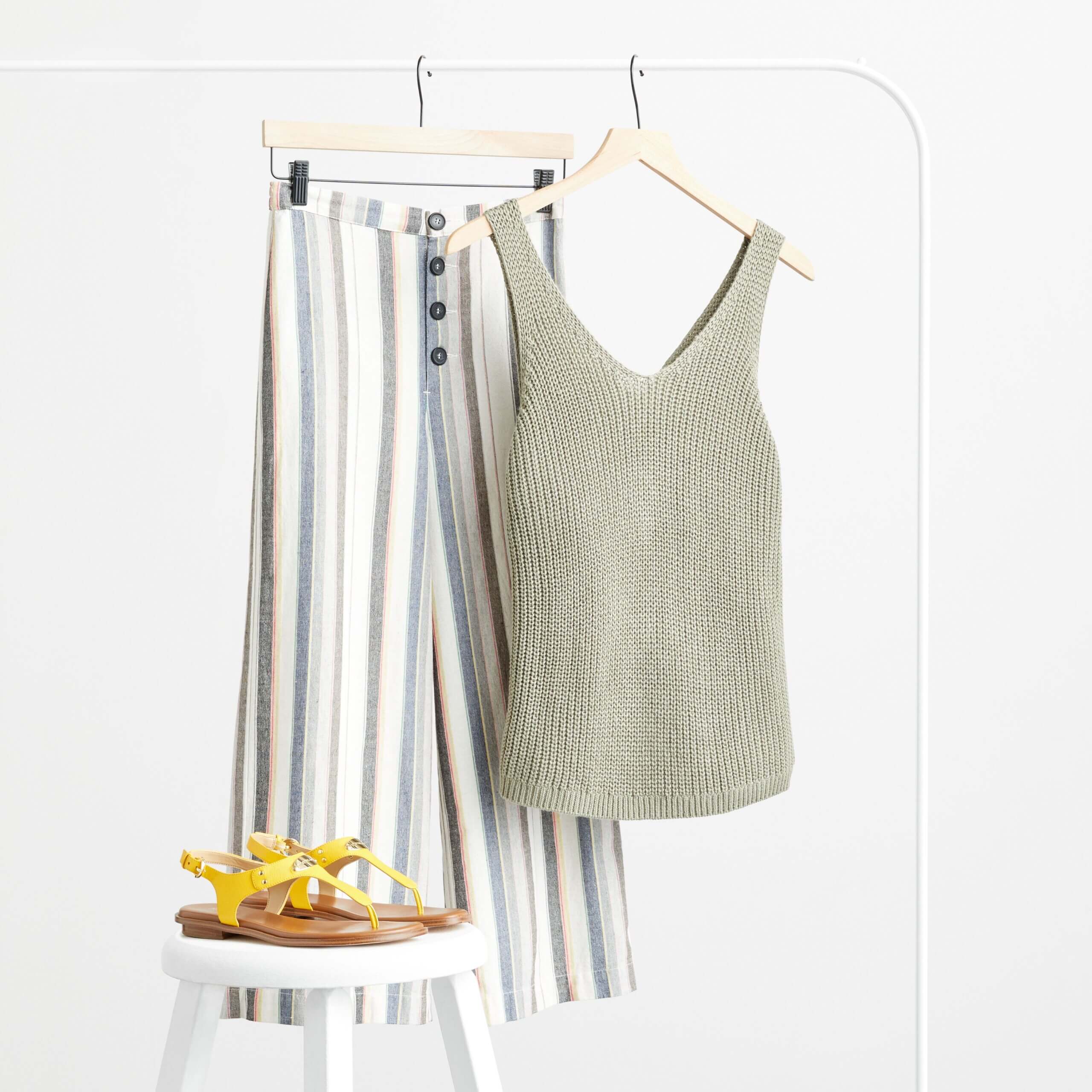 Stitch Fix women’s striped gauchos with green knit tank and yellow sandals on a white stool.
