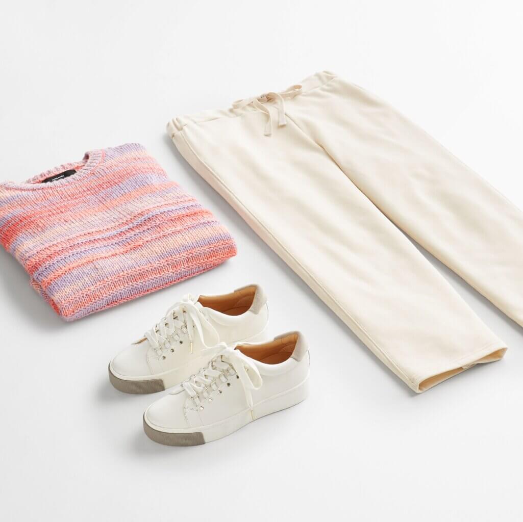 Stitch Fix women’s beige culottes with pink and blue striped sweater and off-white sneakers.