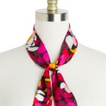 Stitch Fix women’s pink, black, green and white floral silk scarf tied around neck of bust form.