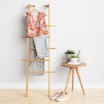 Stitch Fix Women’s Easter outfit featuring vertical striped pants, floral orange blouse and beige sneakers.