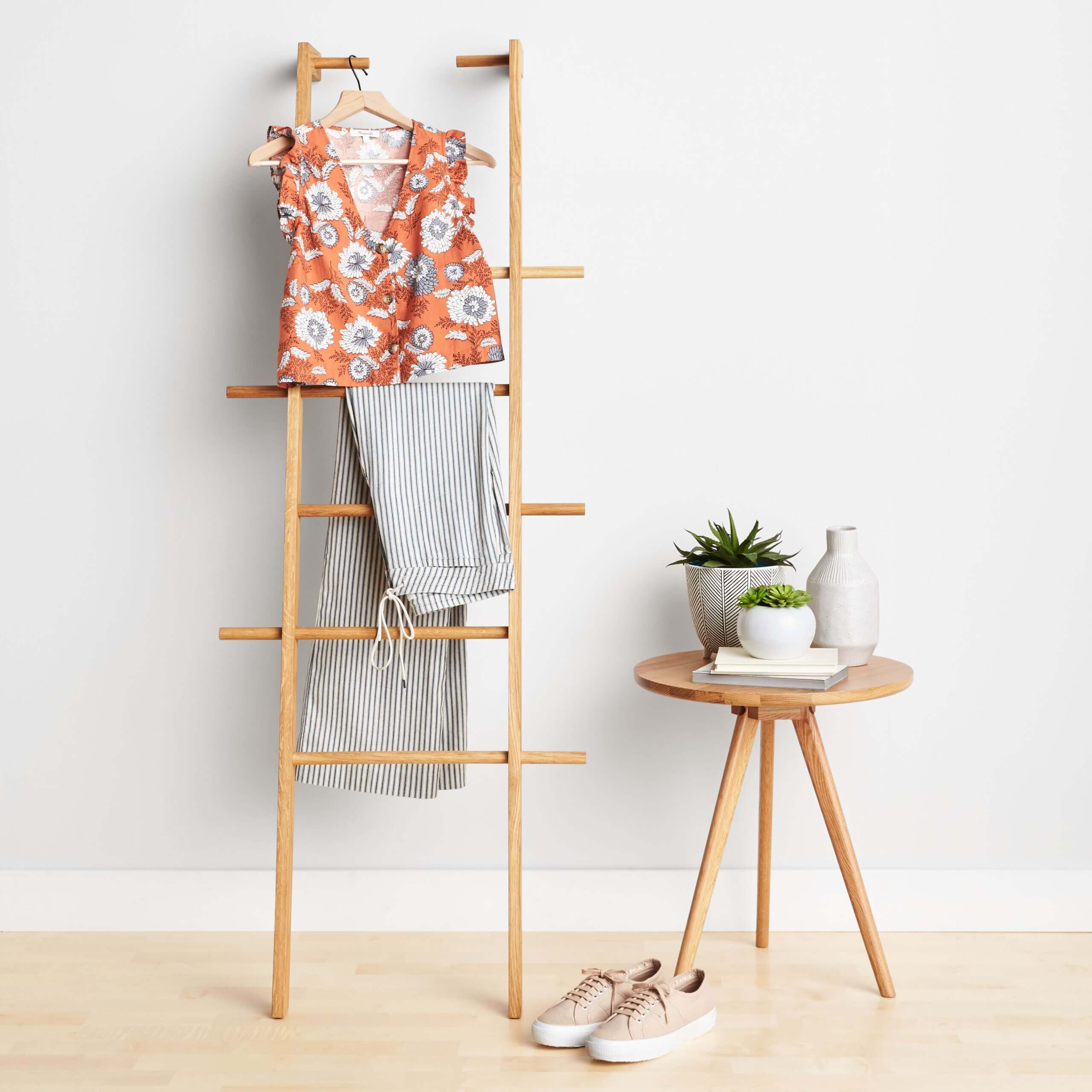 Stitch Fix Women’s Easter outfit featuring vertical striped pants, floral orange blouse and beige sneakers.