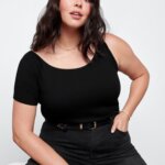 Stitch Fix Women’s model wearing a grunge outfit with black jeans, belt and one-shoulder T-shirt.