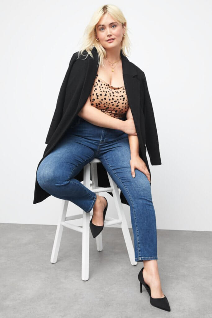 Stitch Fix Women’s model wearing a straight-leg jeans outfit with a polka dot top, black blazer and black pumps.