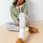 Stitch Fix model wearing a cozy fall aesthetic outfit with joggers, crew neck shirt, hoodie, sock and slippers.