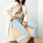Stitch Fix Women’s model wearing a cozy fall aesthetic outfit with a turtleneck sweater, cardigan, jeans, boots and beanie.