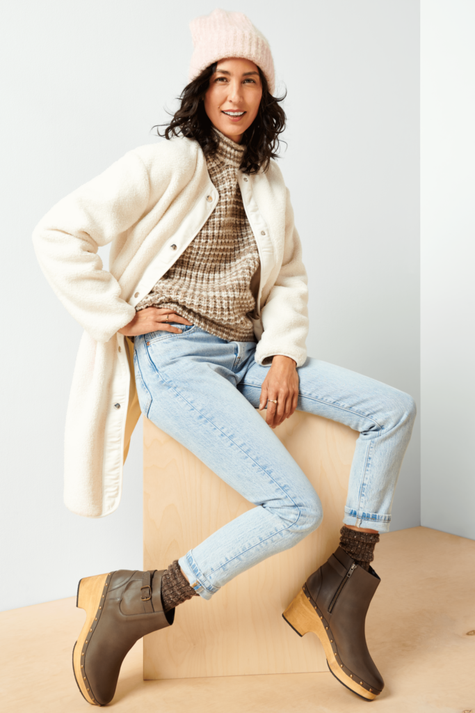 Stitch Fix Women’s model wearing a cozy fall aesthetic outfit with a turtleneck sweater, cardigan, jeans, boots and beanie.