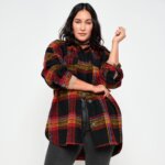 Stitch Fix Women’s model wearing a grunge style outfit with black jeans and a black, red and yellow plaid shacket.
