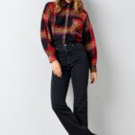 Stitch Fix Women’s model wearing a pumpkin patch outfit with black jeans, plaid blouse, brown boots and red beanie.