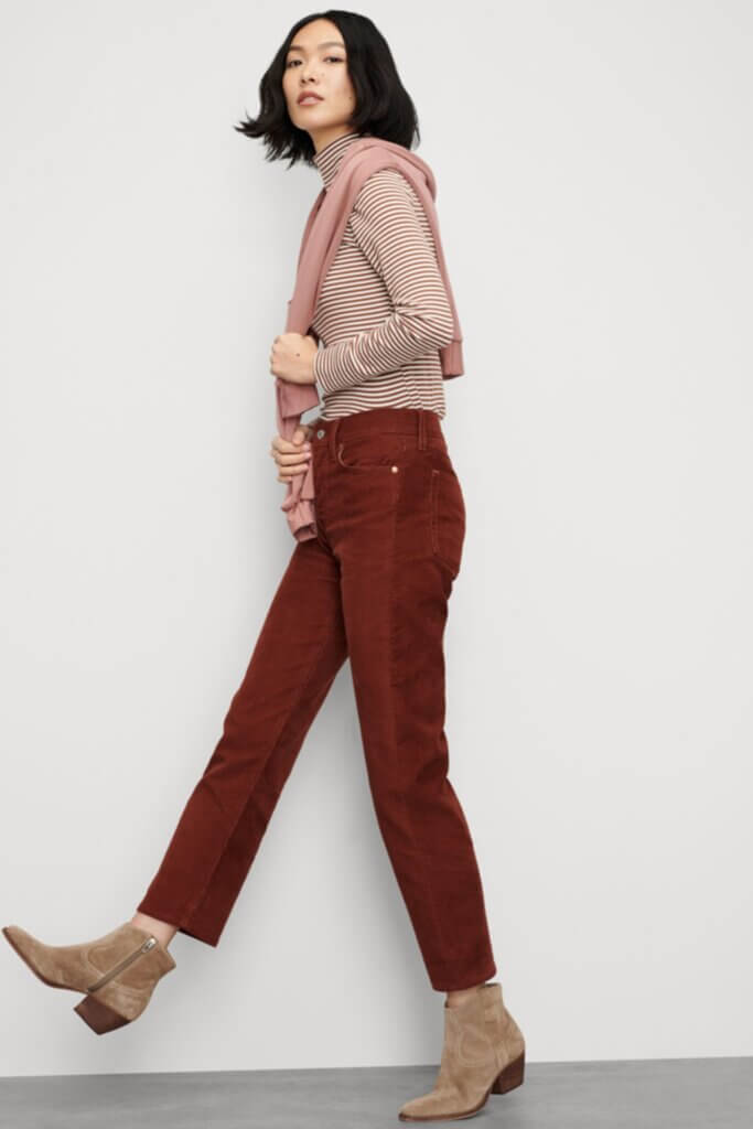 Stitch Fix Women’s model wearing a collegiate fashion outfit with corduroy pants, striped turtleneck, sweater and booties.