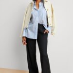 Stitch Fix Women’s model wearing blue and white striped oversized button-up, black slacks, white sneakers and off-white jacket