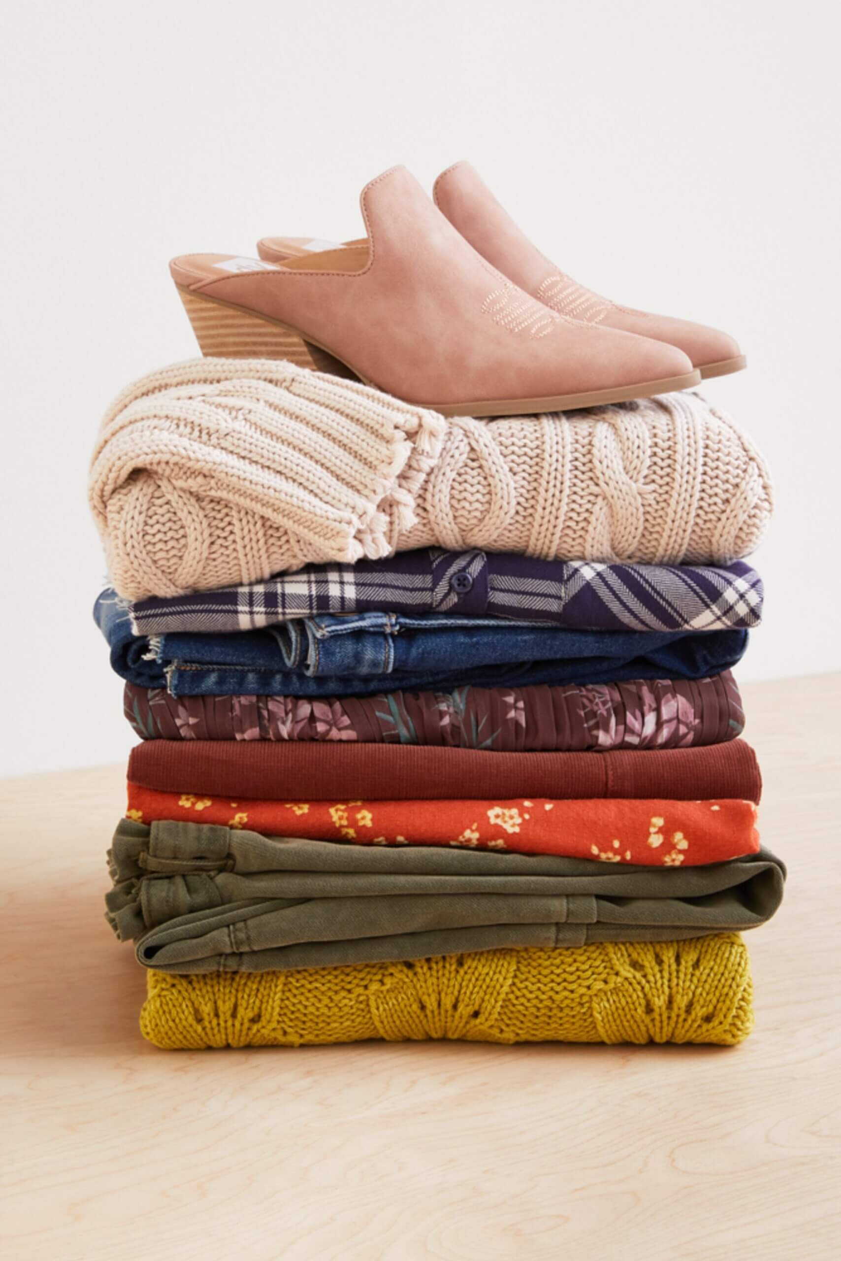 Stitch Fix Women’s stack of pumpking patch style fall sweaters, flannels, blouses and a pair of mule heels.
