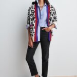 Stitch Fix Women’s model wearing a blue button-up, black jeans, animal print cardigan and black loafers.