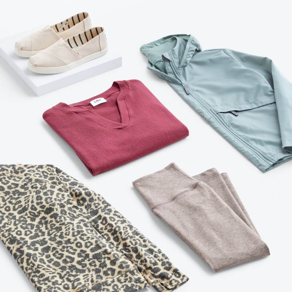 Stitch Fix women’s hiking outfit with leopard-print sweatshirt, burgundy knit top, brown leggings, olive jacket and white slip-on sneakers.