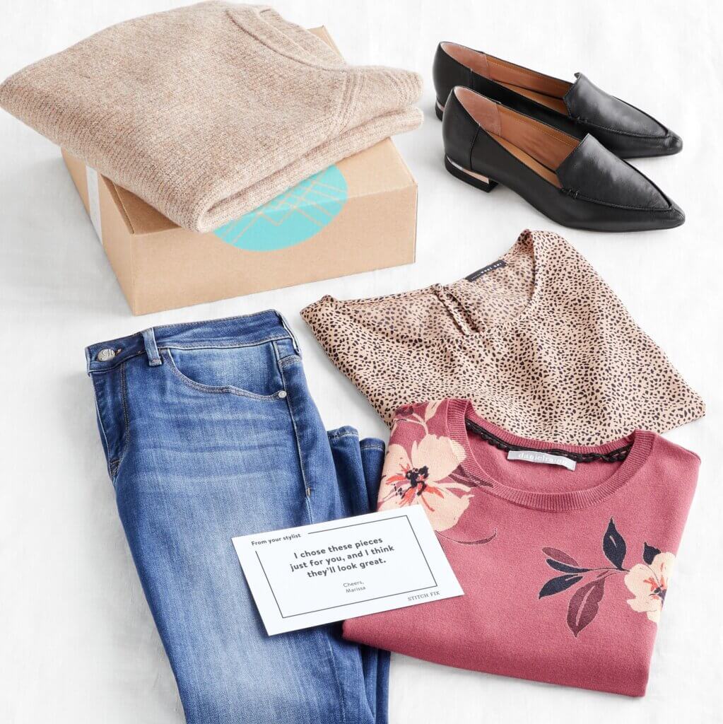 Stitch Fix box featuring jeans, sweaters, a printed blouse and black loafers.