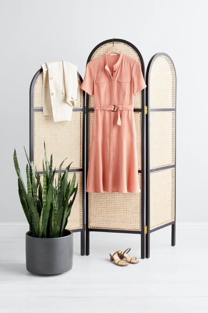 Stitch Fix women’s business formal outfit with coral belted shirt dress and beige blazer hanging up next to brown heels.