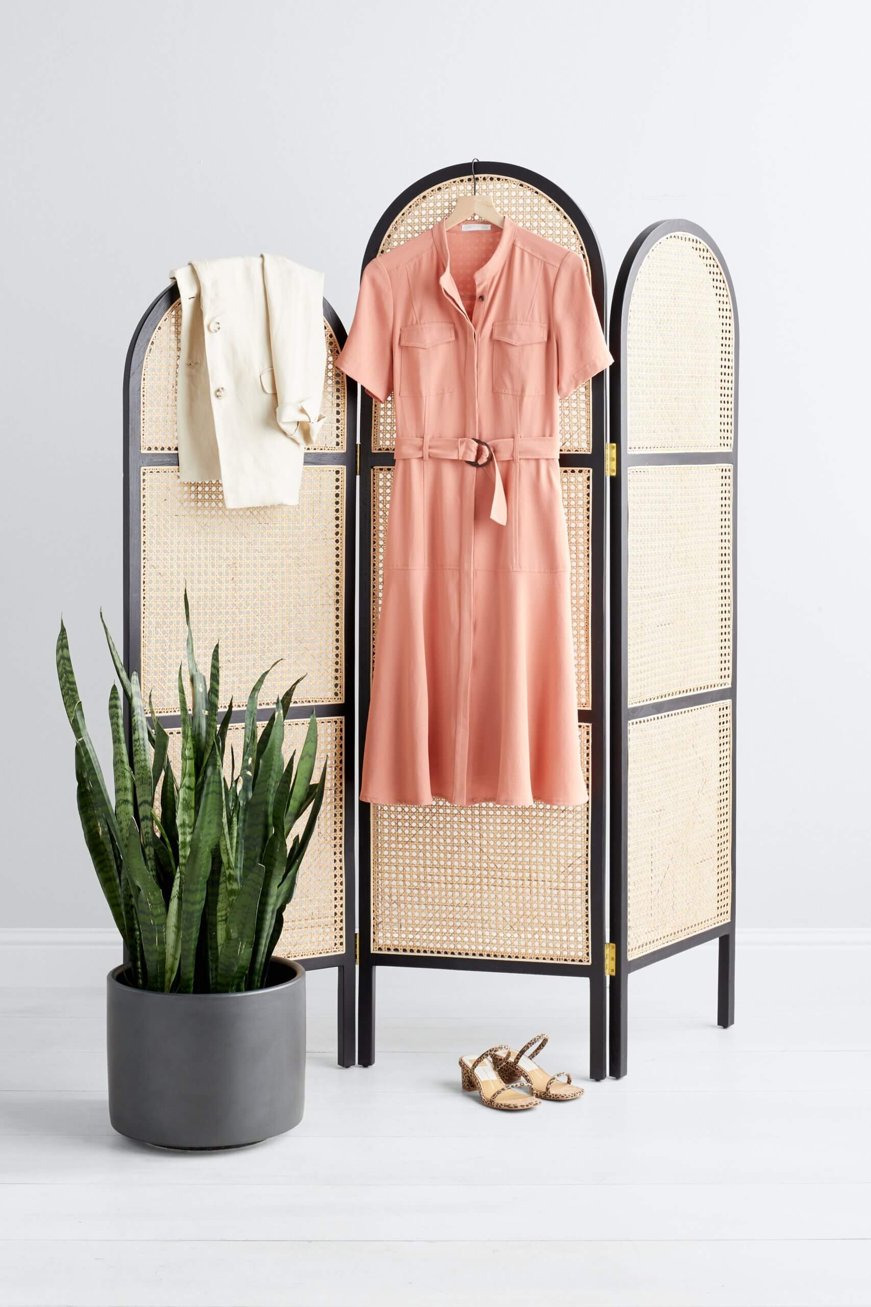 Stitch Fix women’s business formal outfit with coral belted shirt dress and beige blazer hanging up next to brown heels.
