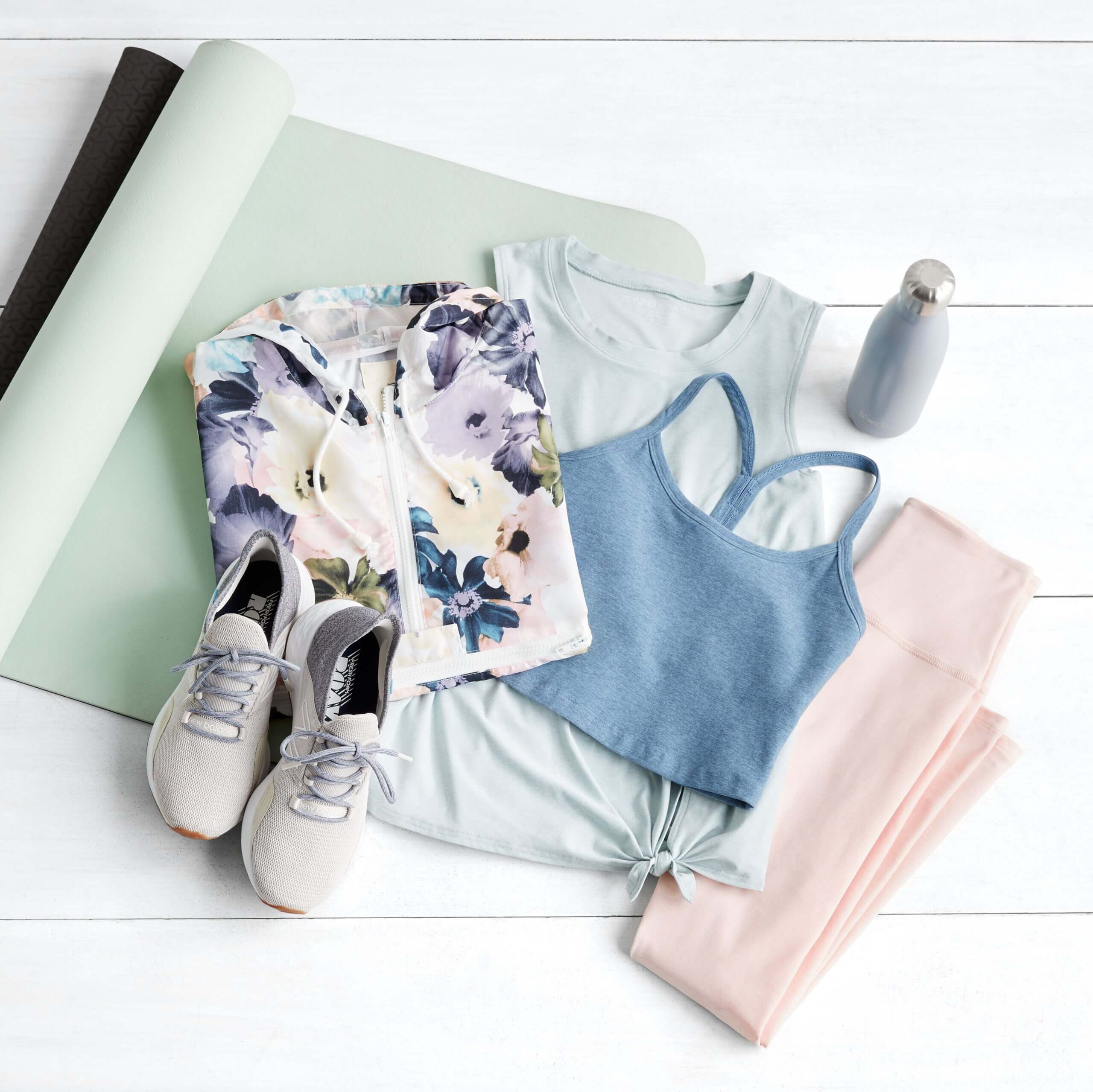 Stitch Fix women’s yoga outfit featuring floral sweatshirt, knotted tank, sports bra, leggings, sneakers and water bottle on yoga mat.