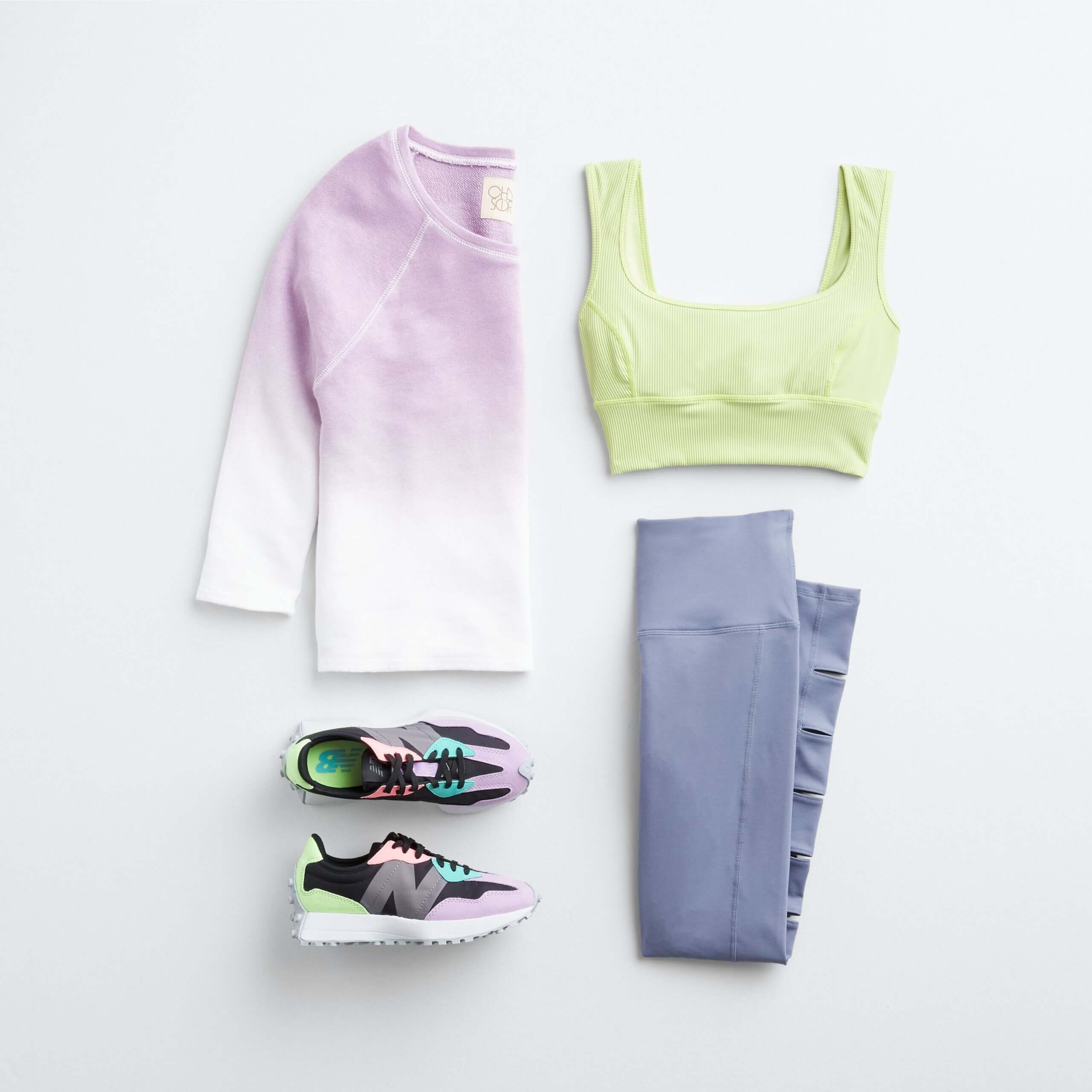 Stitch Fix women's yoga outfit featuring purple and white ombre shirt, green sports bra, purple leggings and black sneakers.