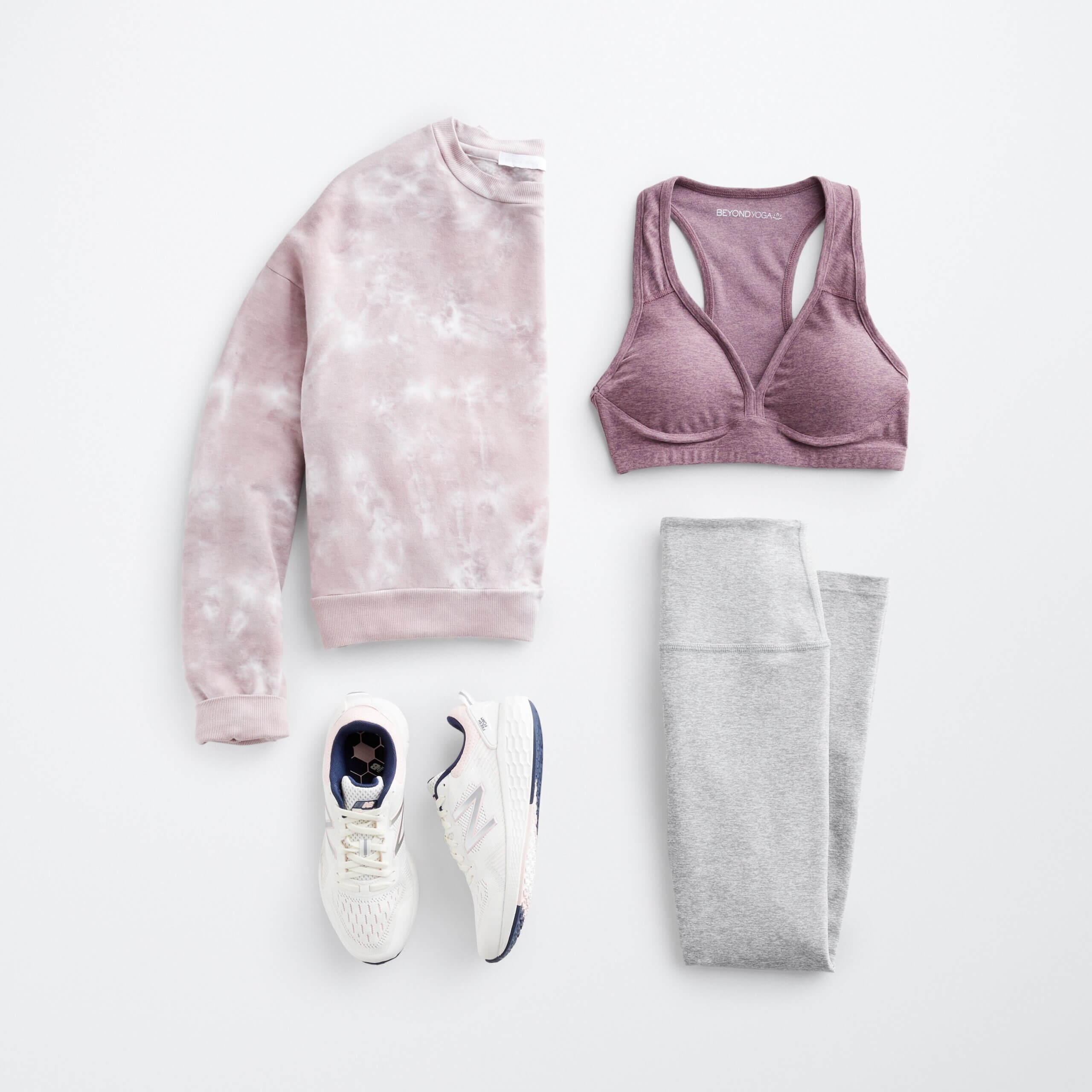 Stitch Fix women’s hiking outfit with purple sports bra, purple and white printed pullover, grey leggings and white sneakers.