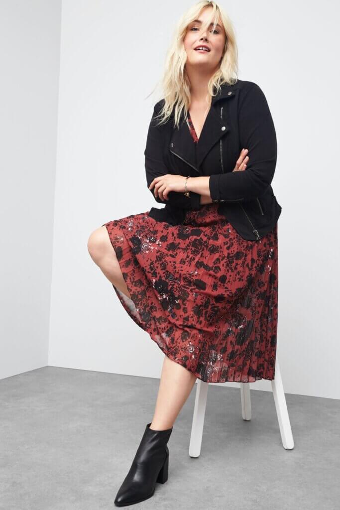 Stitch Fix women's Valentine's Day outfit on model wearing floral print sequin dress with moto jacket over and booties.