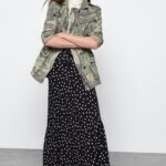 Stitch Fix model wearing printed maxi skirt, white T-shirt, camo print jacket and black combat boots.