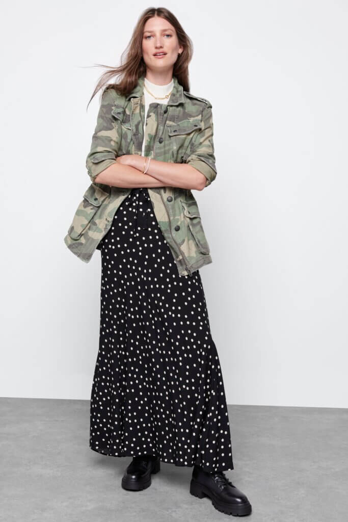 Stitch Fix model wearing printed maxi skirt, white T-shirt, camo print jacket and black combat boots.