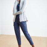 Stitch Fix model wearing women's golf attire outfit including navy shirt, navy cargo capris, grey jacket and sneakers.