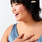 Stitch Fix model wearing a blue dress with a gold ring and gold hair clip accessories.