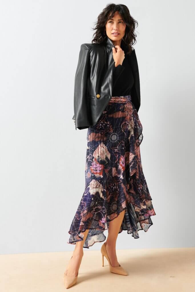 Stitch Fix model wearing women’s business formal outfit with navy floral midi skirt, black blouse and faux leather blazer.