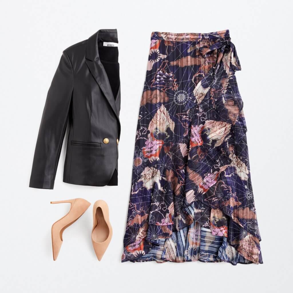 Stitch Fix women's semi-formal wedding attire outfit with black leather blazer, navy printed wrap skirt and tan pumps.