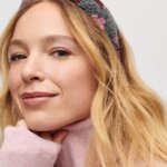Stitch Fix model wearing women's regencycore outfit featuring floral knotted headband and pink turtleneck sweater.