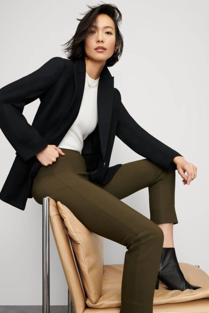 Stitch Fix women’s model wearing modern business formal outfit with olive pants, white shirt, black blazer and black booties.