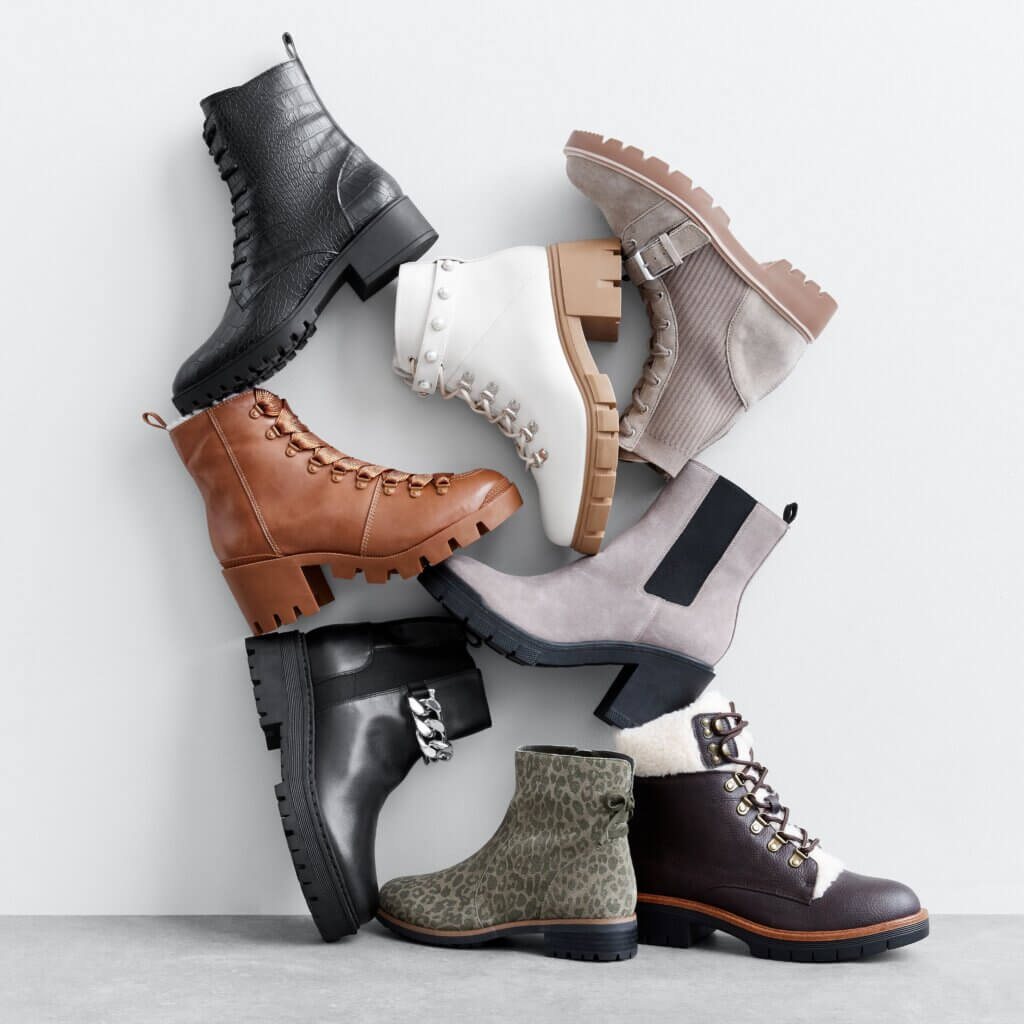 Stitch Fix women’s boots in black, brown, white, gray, green and taupe leaning against a wall.