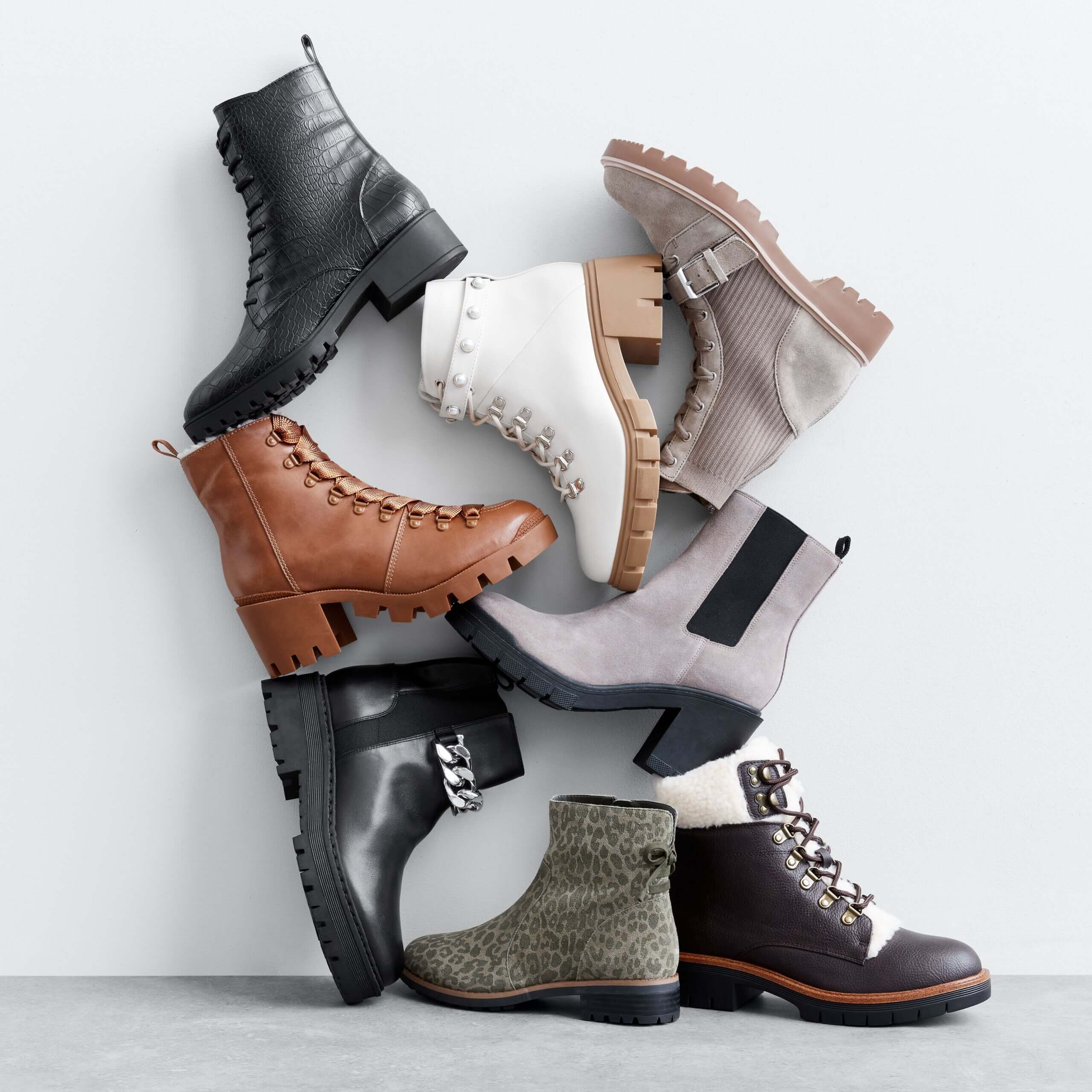 Stitch Fix women’s boots in black, brown, white, gray, green and taupe leaning against a wall.
