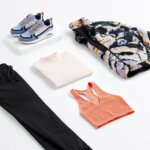 Stitch Fix women’s what to wear hiking outfit with black joggers, coral sports bra, white long-sleeve shirt, sneakers and graphic fleece jacket.