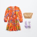 Stitch Fix women’s beachy cocktail wedding attire with tropical printed mini dress, rattan clutch and lilac heels.