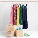 Stitch Fix women’s clothing rack with colorful dresses with heeled sandals and woven bag accessories.