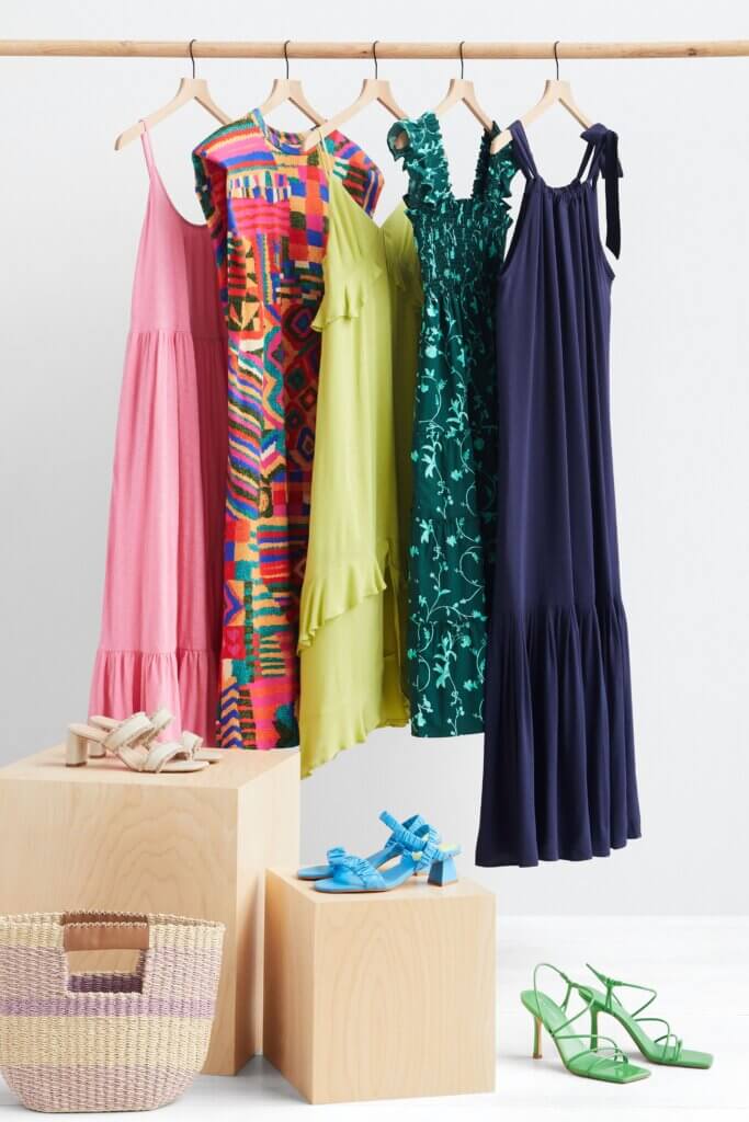 Stitch Fix women’s collection of five various garden party attire dresses hanging on a rack next to three heels and tote bag.