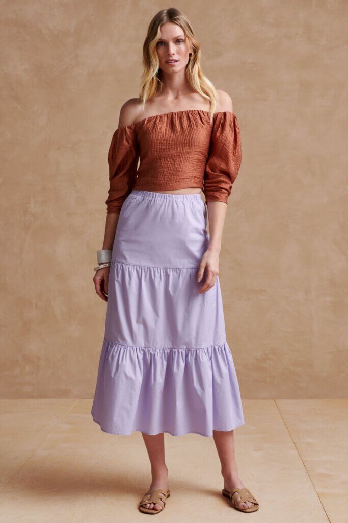 Stitch Fix women’s Bridgerton inspired outfit featuring lavender tiered midi skirt and brown off-the-shoulder smocked top.