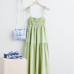 Stitch Fix women’s casual wedding beach attire with green tiered maxi dress hanging next to bag with chain strap and heels.
