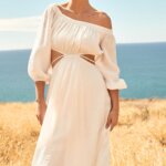 Stitch Fix model wearing women’s beach bridal wedding attire with white off-the-shoulder cut-out dress on the coast.