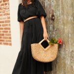 Stitch Fix model wearing women’s coastal grandmother outfit with black crop top, maxi skirt and straw purse with flower.