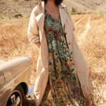 Stitch Fix model wearing women’s casual beach wedding attire with multicolor floral maxi dress and tan trench jacket.
