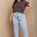 Stitch Fix model wearing women’s coastal grandmother outfit with light blue jeans, grey T-shirt and white sandals.