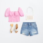 Stitch Fix women's Y2K fashion outfit with pink puffed-sleeve top, denim shorts, white bag and white heels with wooden sole.