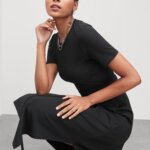 Stitch Fix model wearing black dress, blue heeled sandals with silver necklace and ring accessories.