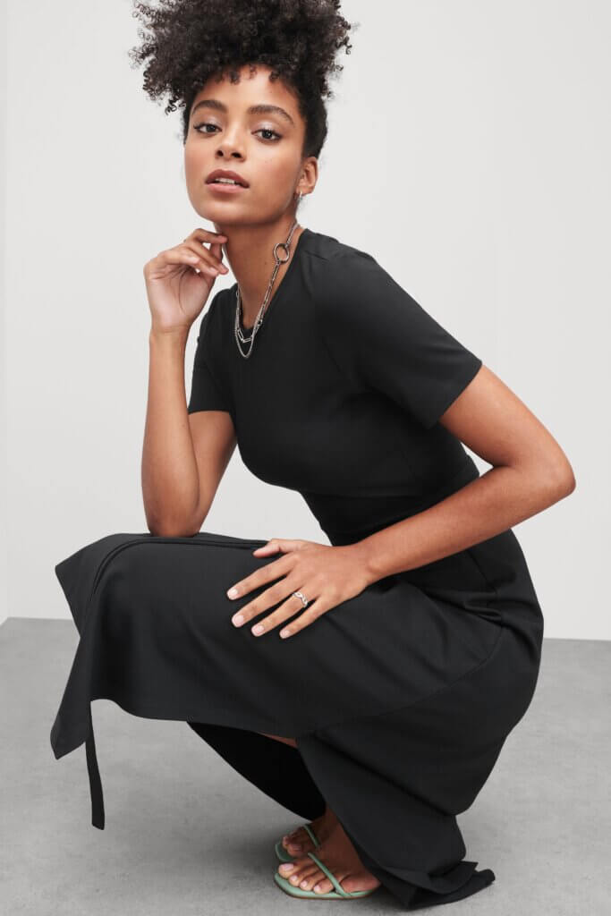 Stitch Fix model wearing black dress, blue heeled sandals with silver necklace and ring accessories.
